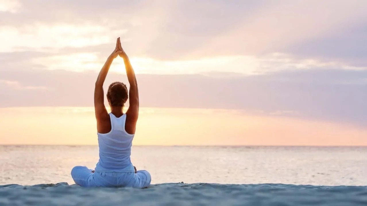 A women doing yoga on a beachside