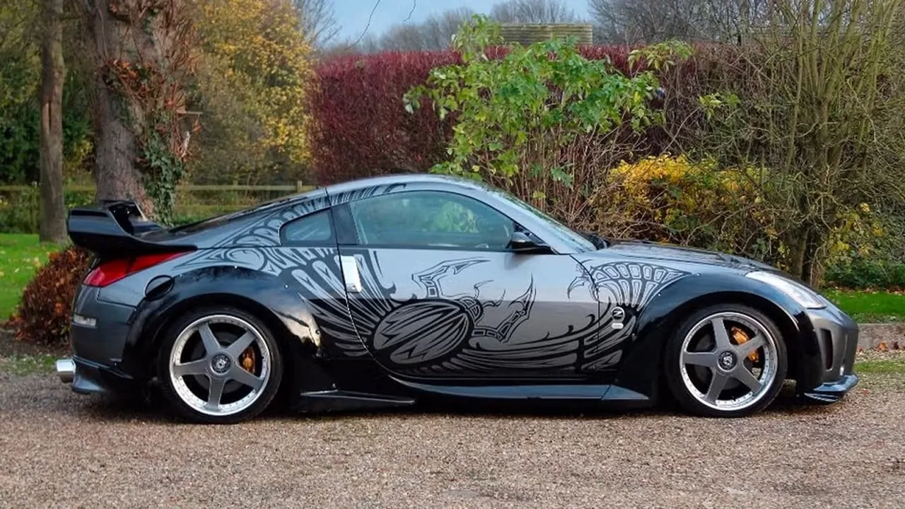 A patterned Tokyo drift car is parked by the roadside
