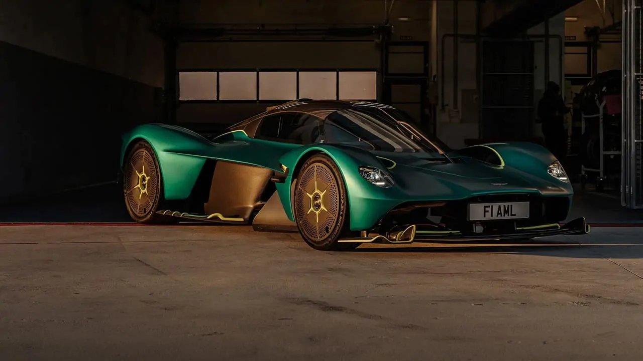 A green Aston Martin Valkyrie is parked outside of the workshop