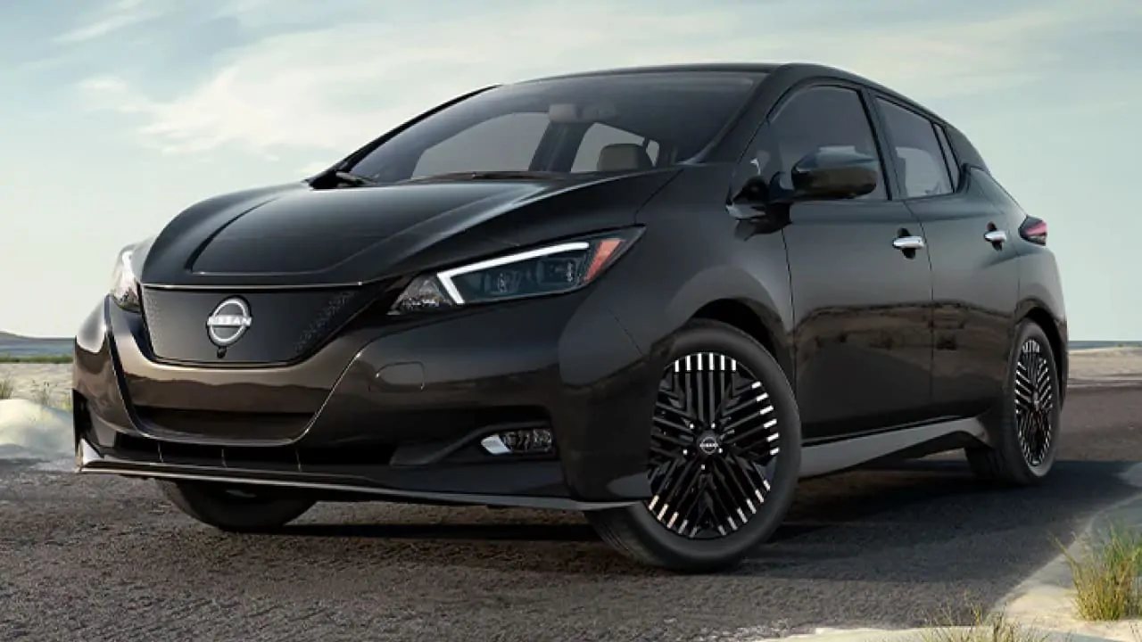 A black Nissan Leaf is parked on the side of the road