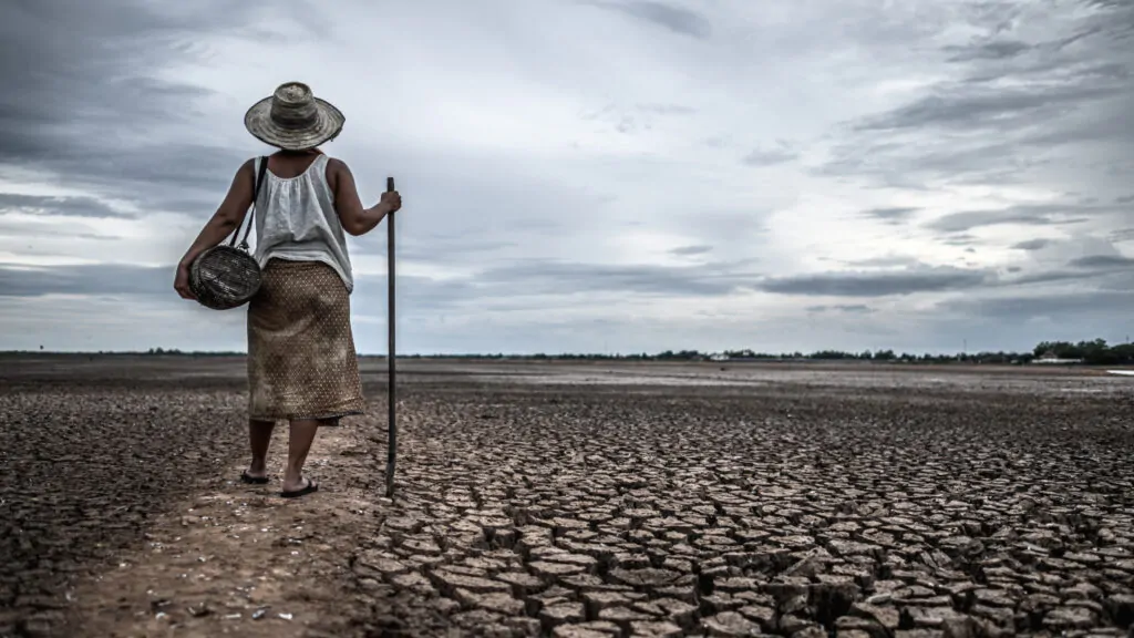 Women standing on a dry soil, which is clearly shows that how deforestation affect climate change