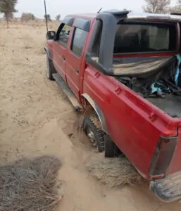 A red 4x4 truck car drenched in cholistan desert sand