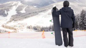 A guy holding a snowboard
